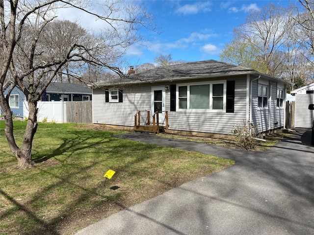view of front of property with fence, a front lawn, and a chimney