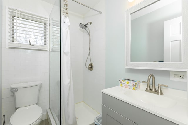 full bath with vanity, toilet, and a stall shower