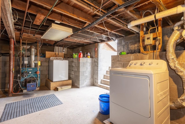 unfinished basement with washer / dryer and a heating unit