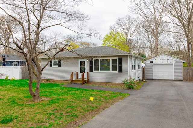 single story home with an outbuilding, a front lawn, driveway, fence, and a garage