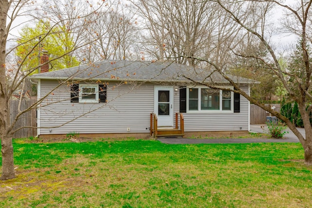 back of house with fence, a chimney, and a yard