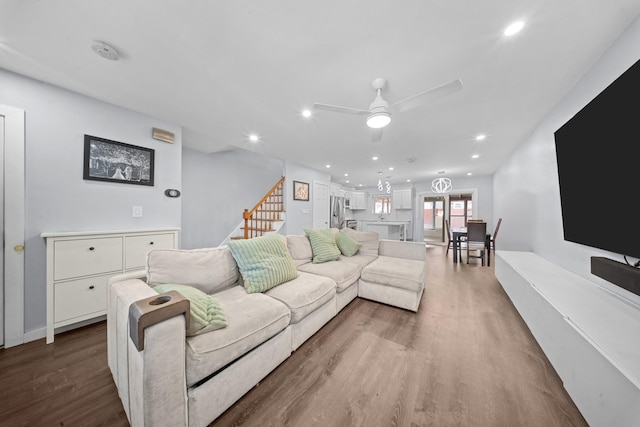 living area with a ceiling fan, wood finished floors, recessed lighting, and stairway
