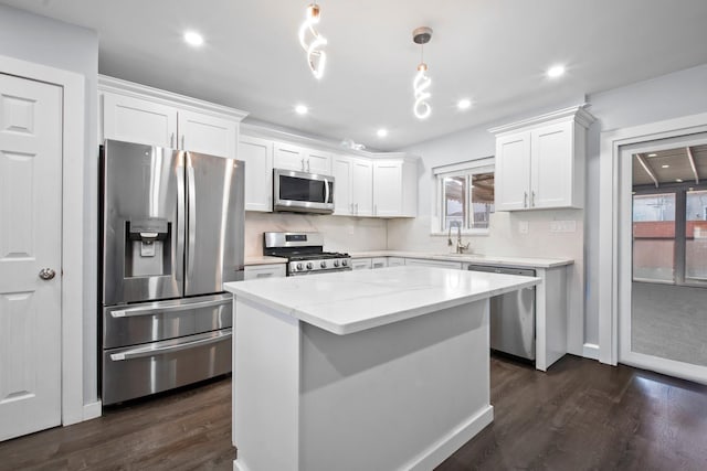 kitchen featuring dark wood-type flooring, white cabinetry, stainless steel appliances, and a sink