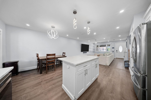 kitchen with wood finished floors, freestanding refrigerator, and white cabinetry