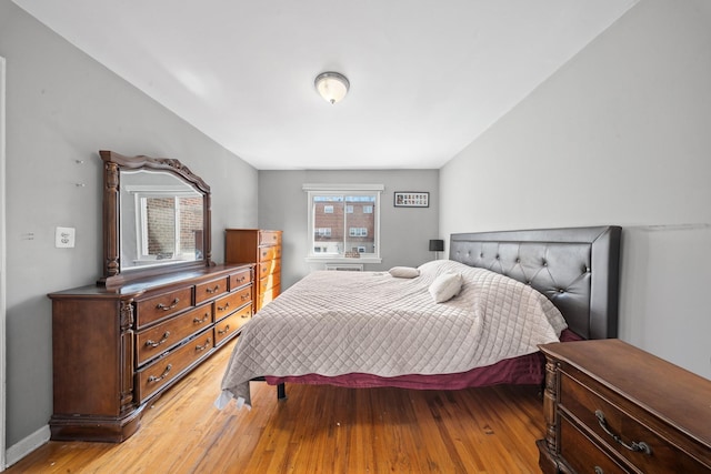 bedroom featuring light wood finished floors and baseboards