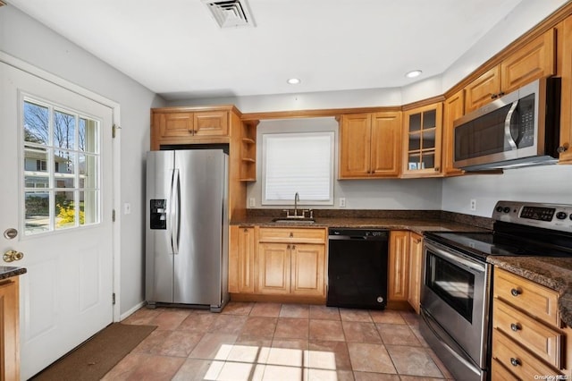 kitchen featuring glass insert cabinets, open shelves, appliances with stainless steel finishes, a sink, and visible vents