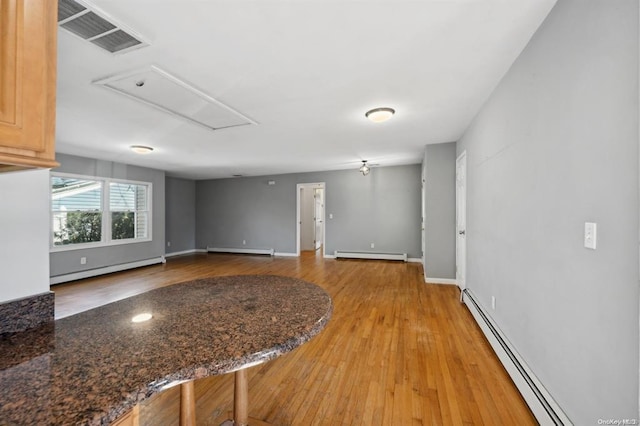 interior space with baseboard heating, visible vents, and attic access
