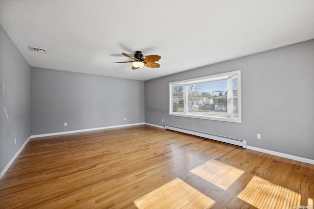 unfurnished room featuring wood finished floors, ceiling fan, baseboard heating, and baseboards
