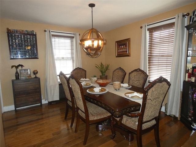 dining room featuring a notable chandelier, dark wood-style flooring, and baseboards