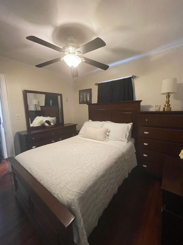 bedroom with dark wood-type flooring, crown molding, and a ceiling fan
