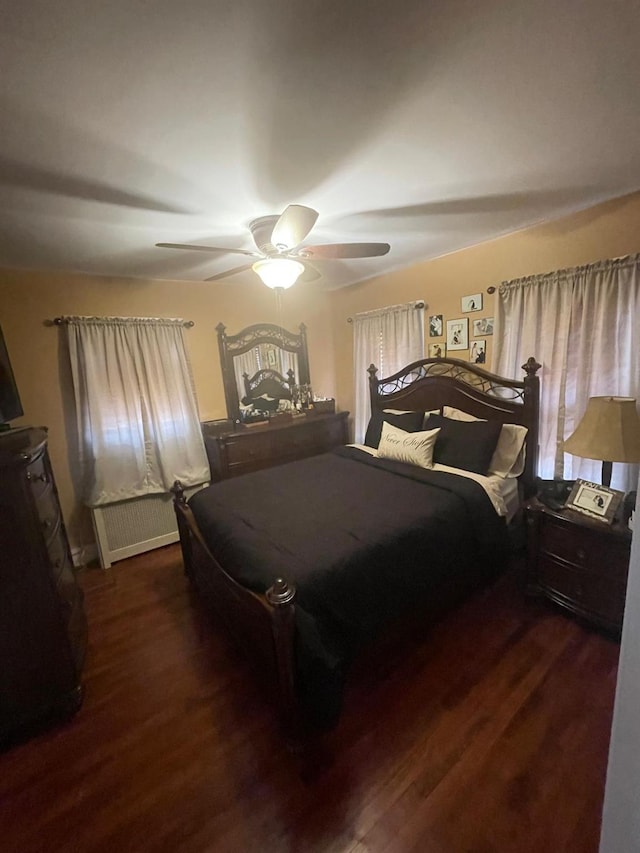 bedroom featuring wood finished floors, radiator heating unit, and a ceiling fan
