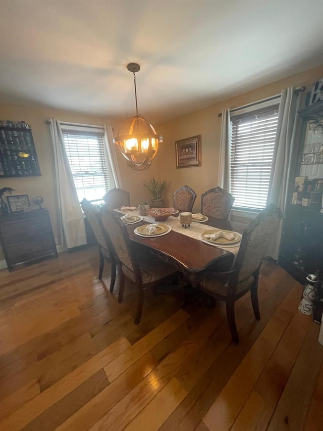 dining room with light wood-style flooring and a notable chandelier
