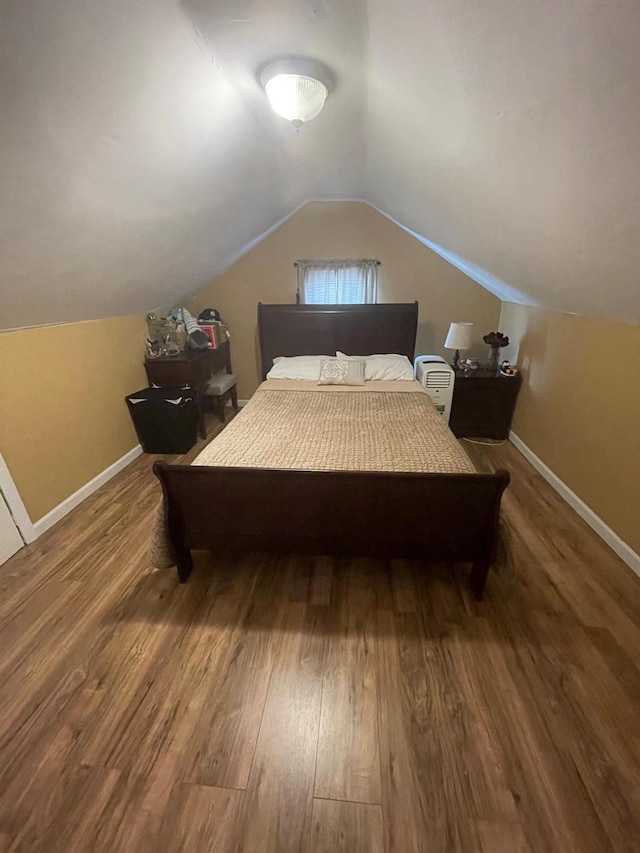 bedroom with lofted ceiling, baseboards, and wood finished floors