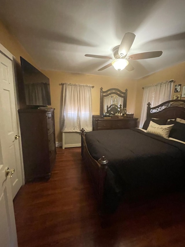 bedroom featuring dark wood-style flooring, baseboards, and ceiling fan
