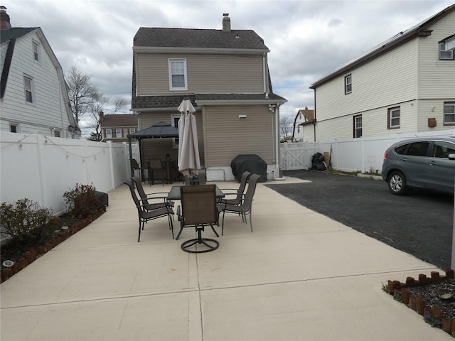 view of patio featuring area for grilling, outdoor dining space, a fenced backyard, and a gate