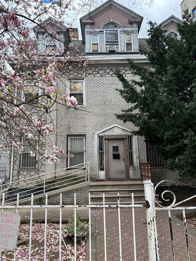 view of front facade featuring brick siding and a fenced front yard