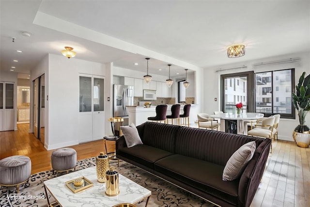 living area with light wood finished floors, recessed lighting, and baseboards