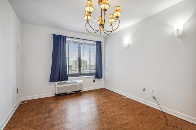 spare room featuring wood finished floors, a chandelier, a wall mounted air conditioner, and baseboards