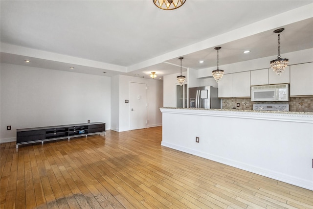 100 W Broadway Unit 4C, Long Beach, NY 11561 - unfurnished living room with a chandelier, light wood finished floors, recessed lighting, and baseboards