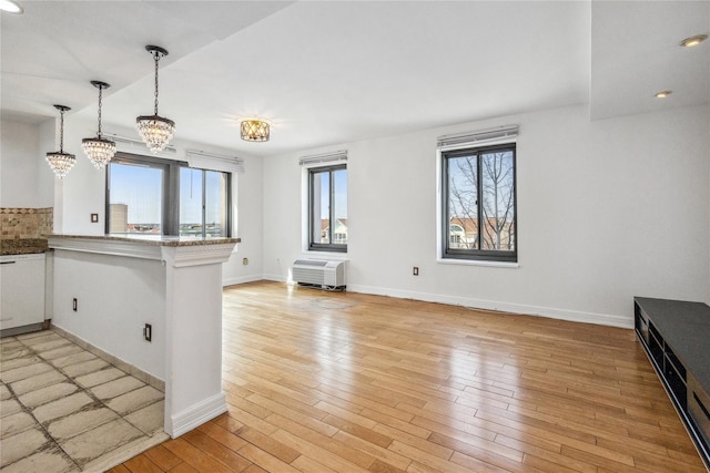100 W Broadway Unit 4C, Long Beach, NY 11561 - kitchen featuring a peninsula, light wood-style flooring, pendant lighting, and baseboards