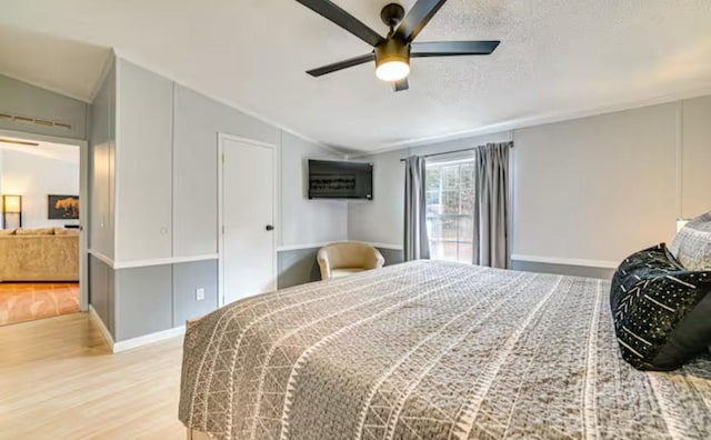 bedroom featuring a textured ceiling, vaulted ceiling, a ceiling fan, and wood finished floors