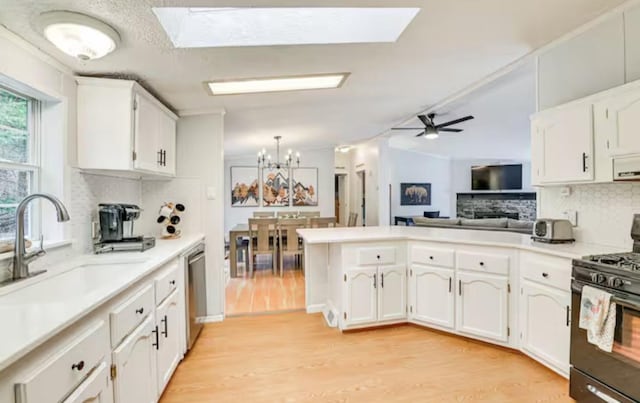 kitchen featuring black gas stove, tasteful backsplash, a peninsula, dishwasher, and a sink