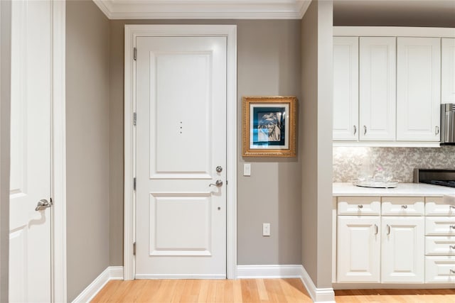 1 Christie Pl Unit 205W, Scarsdale, NY 10583 - doorway to outside with light wood-style floors, ornamental molding, and baseboards