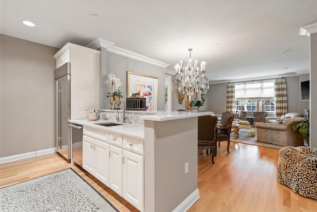 1 Christie Pl Unit 205W, Scarsdale, NY 10583 - kitchen with a sink, light wood-style floors, a center island with sink, ornamental molding, and open floor plan