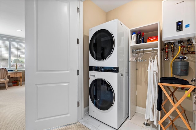 1 Christie Pl Unit 205W, Scarsdale, NY 10583 - washroom featuring stacked washer / dryer, light tile patterned floors, tankless water heater, and laundry area
