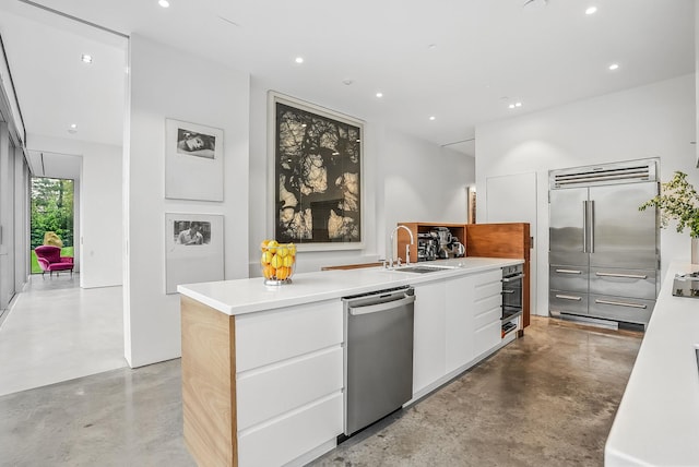 112 Wilson Park Dr, Tarrytown, NY 10591 - kitchen featuring stainless steel appliances, concrete flooring, modern cabinets, a sink, and recessed lighting