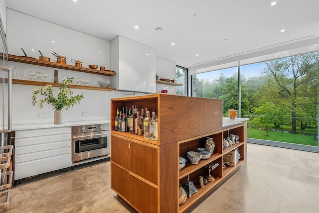 112 Wilson Park Dr, Tarrytown, NY 10591 - bar area featuring stainless steel oven, recessed lighting, concrete flooring, and a wall of windows