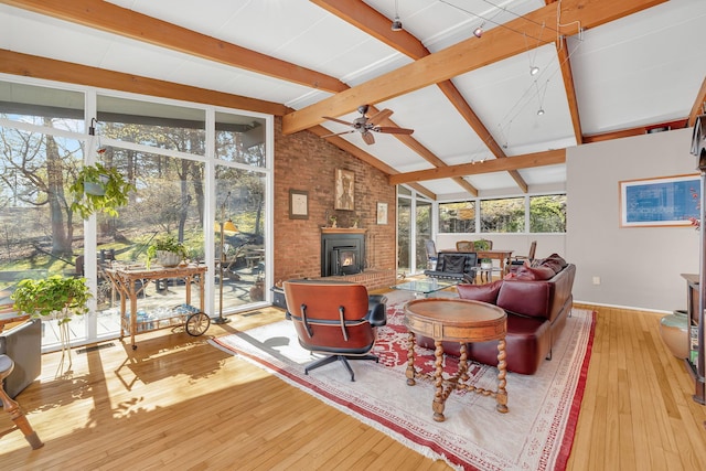 living area featuring a ceiling fan, hardwood / wood-style flooring, vaulted ceiling with beams, and baseboards