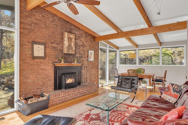 living area featuring wood finished floors, a ceiling fan, visible vents, and vaulted ceiling with beams