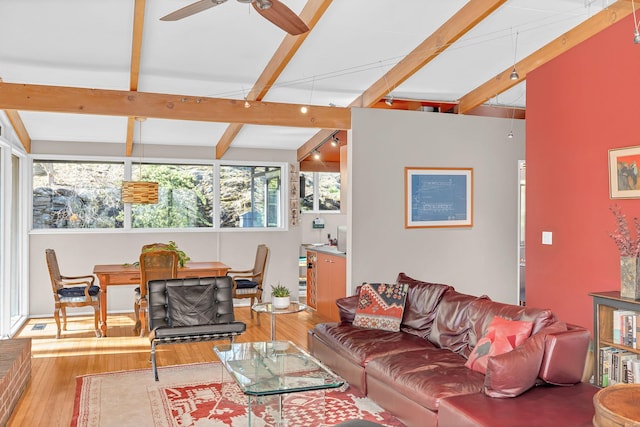 living room featuring ceiling fan, hardwood / wood-style flooring, and vaulted ceiling with beams