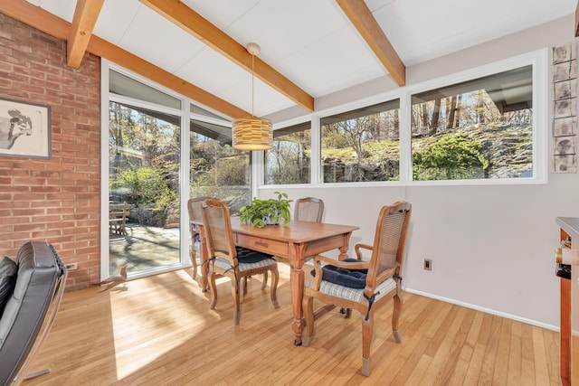 sunroom / solarium with a deck, hardwood / wood-style flooring, baseboards, outdoor dining space, and vaulted ceiling with beams