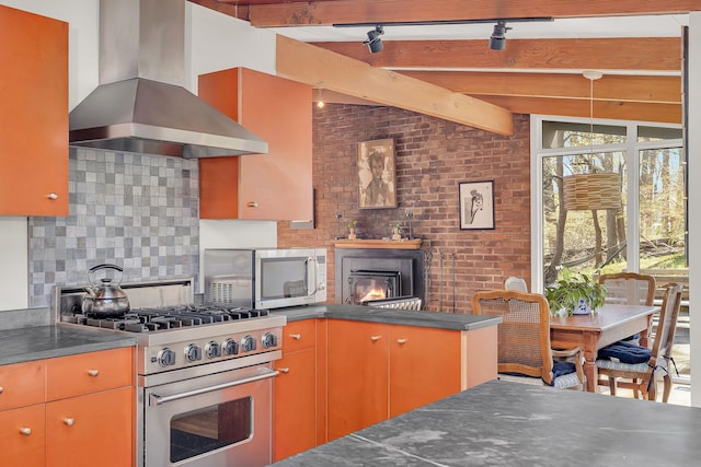 kitchen with appliances with stainless steel finishes, decorative backsplash, dark countertops, and exhaust hood