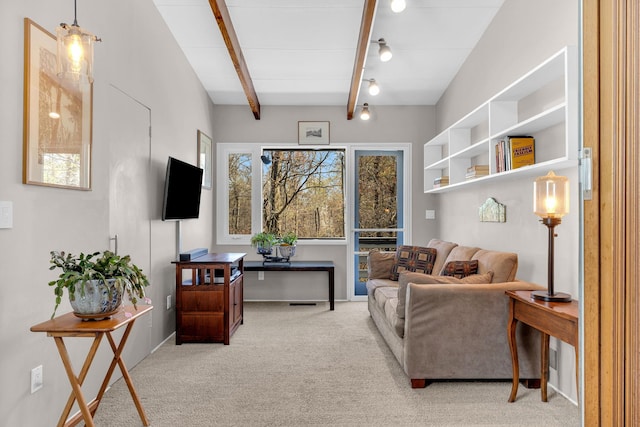 living area featuring beam ceiling and carpet floors