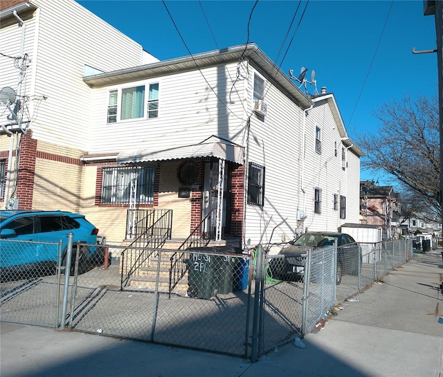 view of property with a gate, brick siding, and a fenced front yard