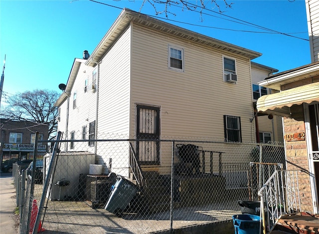 rear view of property with fence, a gate, and cooling unit
