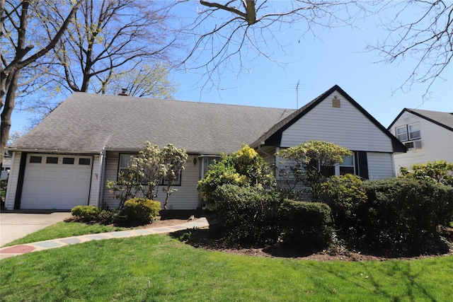 ranch-style house featuring a garage, roof with shingles, a front yard, and concrete driveway