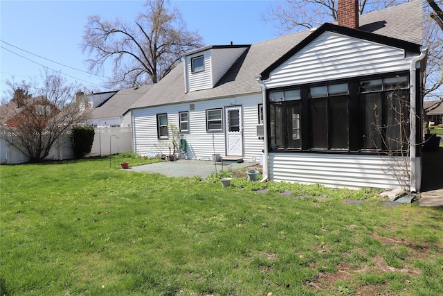 rear view of property with roof with shingles, fence, a patio area, a yard, and a sunroom