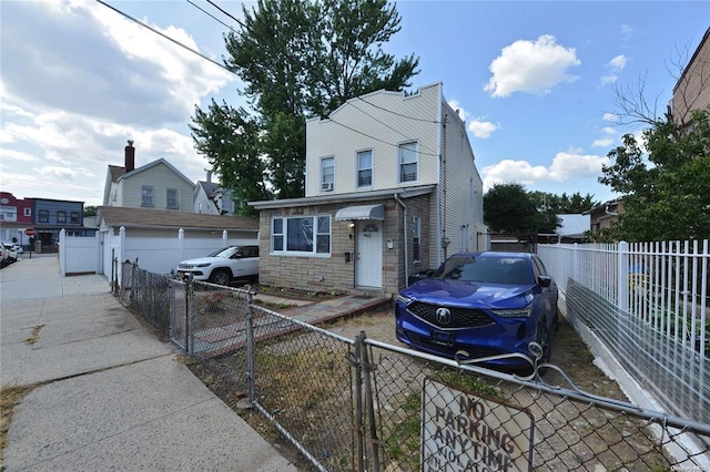 view of front of home featuring a fenced front yard, stone siding, and a gate