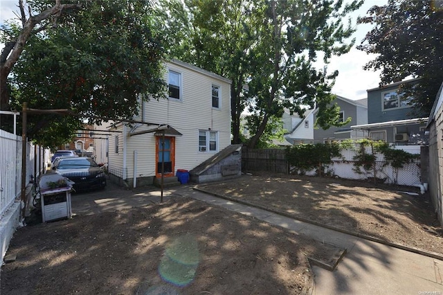 back of property with entry steps and fence private yard
