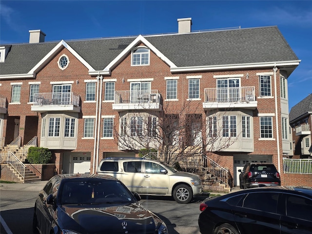 337 Park Cres, College Point, NY 11356 - view of front of house with a garage, brick siding, and stairway