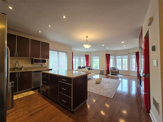 337 Park Cres, College Point, NY 11356 - kitchen featuring appliances with stainless steel finishes, a sink, dark wood-type flooring, open floor plan, and a kitchen island