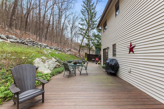 wooden deck with grilling area and outdoor dining area