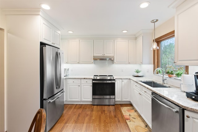 kitchen featuring a sink, appliances with stainless steel finishes, white cabinetry, backsplash, and under cabinet range hood