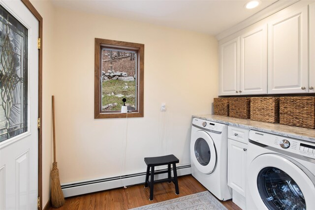 laundry room featuring a baseboard heating unit, washing machine and dryer, recessed lighting, wood finished floors, and cabinet space