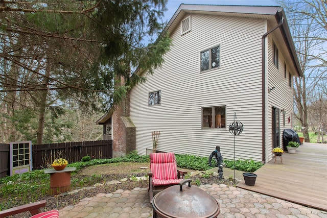 rear view of property with fence, a patio area, and a deck
