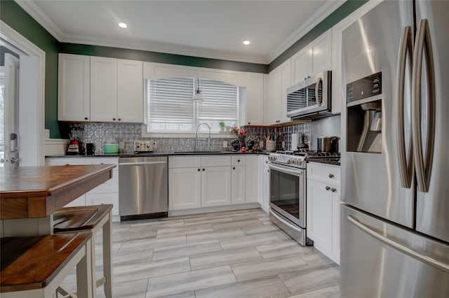 163 N Hamilton St, Poughkeepsie, NY 12601 - kitchen featuring a sink, dark countertops, backsplash, crown molding, and appliances with stainless steel finishes